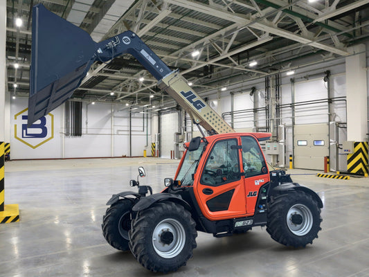 Burwell Material Handling 2024 JLG 823 Ag telehandler with raised bucket parked in front of dealership