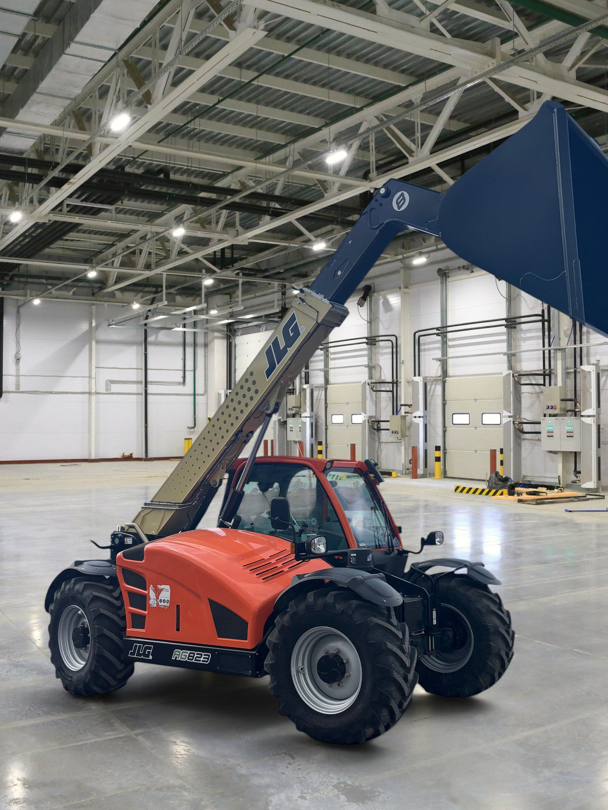 Burwell Material Handling 2024 JLG 823 agricultural telehandler with orange body and extended bucket in a gravel lot.