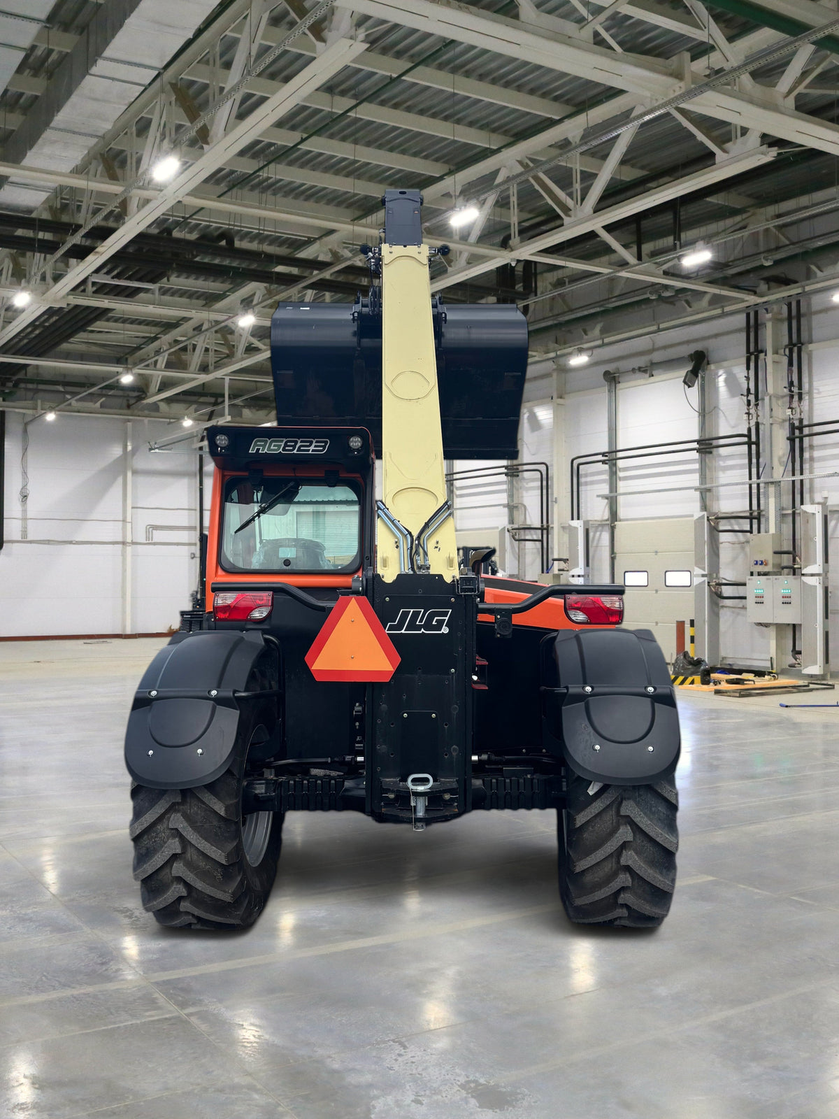Burwell Material Handling 2024 JLG 823 agricultural telehandler with bucket attachment, rear view on gravel lot.