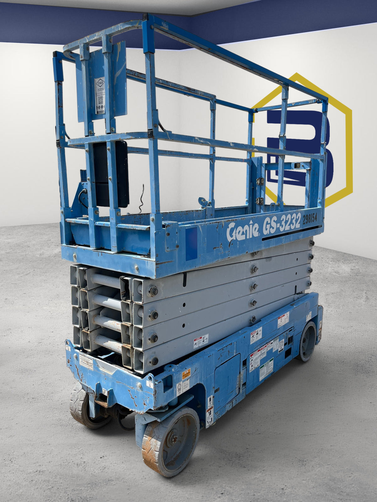 Burwell Material Handling 2013 Genie GS-3232 electric scissor lift in blue, parked on a gravel lot.