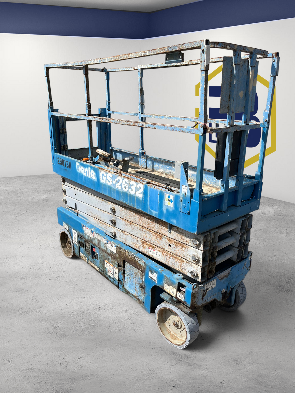 Burwell Material Handling 2013 Genie GS2632 electric scissor lift with blue metal frame in an outdoor equipment yard.