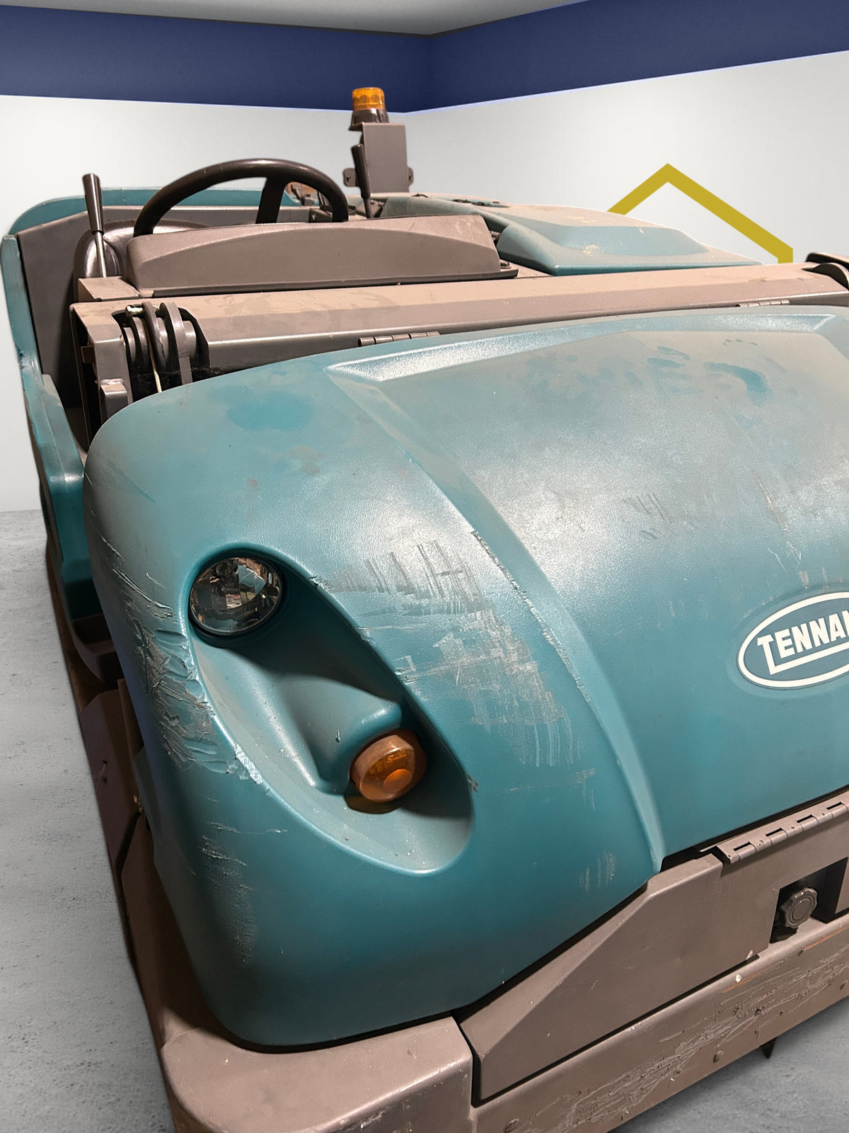 Burwell Material Handling 2000 Tennant S30 industrial rider sweeper in teal with front headlights and steering wheel